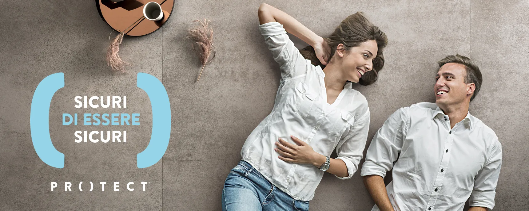 Un uomo e una donna sorridenti sdraiati su un pavimento Protect di Panaria