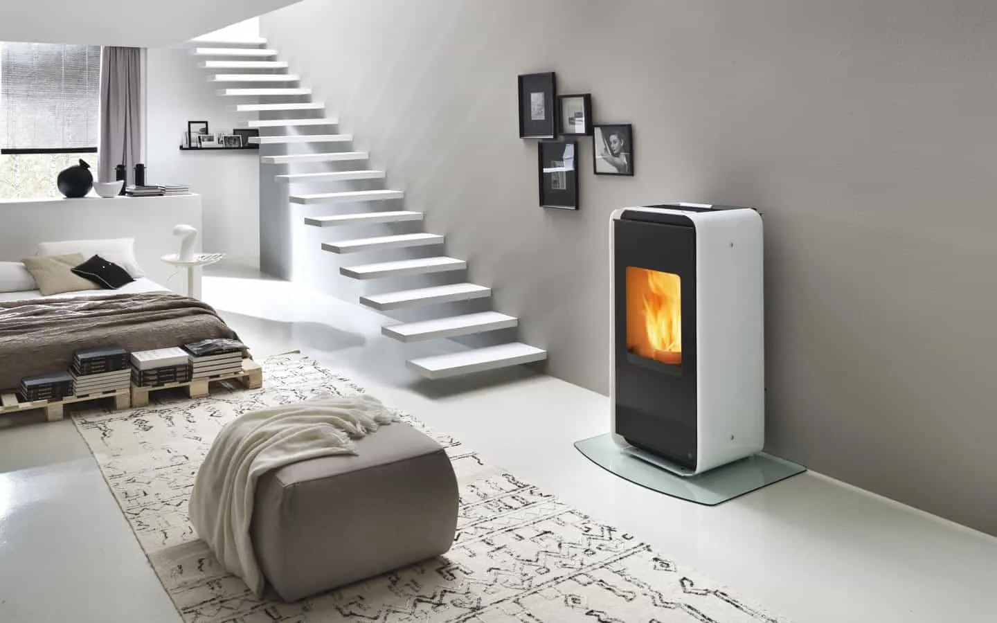 Una stufa bianca Edilkamin all'interno di una stanza con tappeti e cuscini